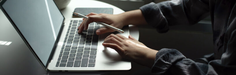 Frauenhände tippen auf Laptop-Tastatur