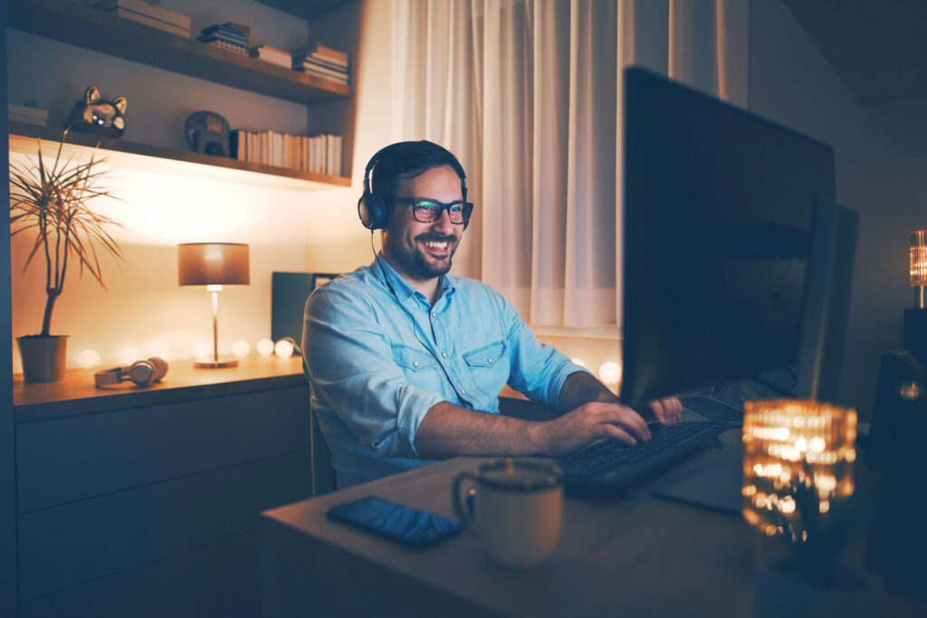 Ein Mann sitzt abends vor dem Computer im Homeoffice: Das Gesetz zur Arbeitszeiterfassung soll gesunde Arbeitsbedingungen schaffen – auch im Homeoffice. 