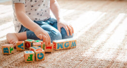 Kita-Kind spielt mit Buchstaben-Bauklötzen