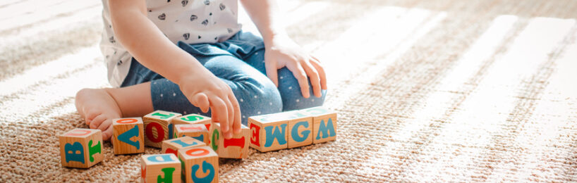 Kita-Kind spielt mit Buchstaben-Bauklötzen